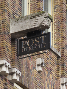 847706 Afbeelding van het smeedijzeren uithangbord 'Post Utrecht', onder een spuwer aan de voorgevel van Bibliotheek ...